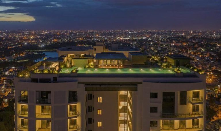 The Vimaana Pool Deck Lit Up At Twilight - Svasa Homes
